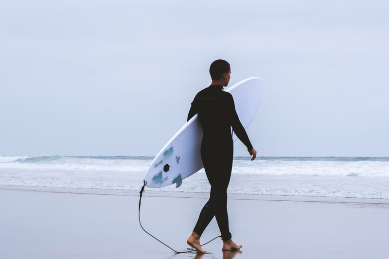 wetsuit, walking, 5K, sport, ocean, leisure activity, black, walk, carrying, beach, sky, water, day, full length, lifestyles, real people, pacific, nature