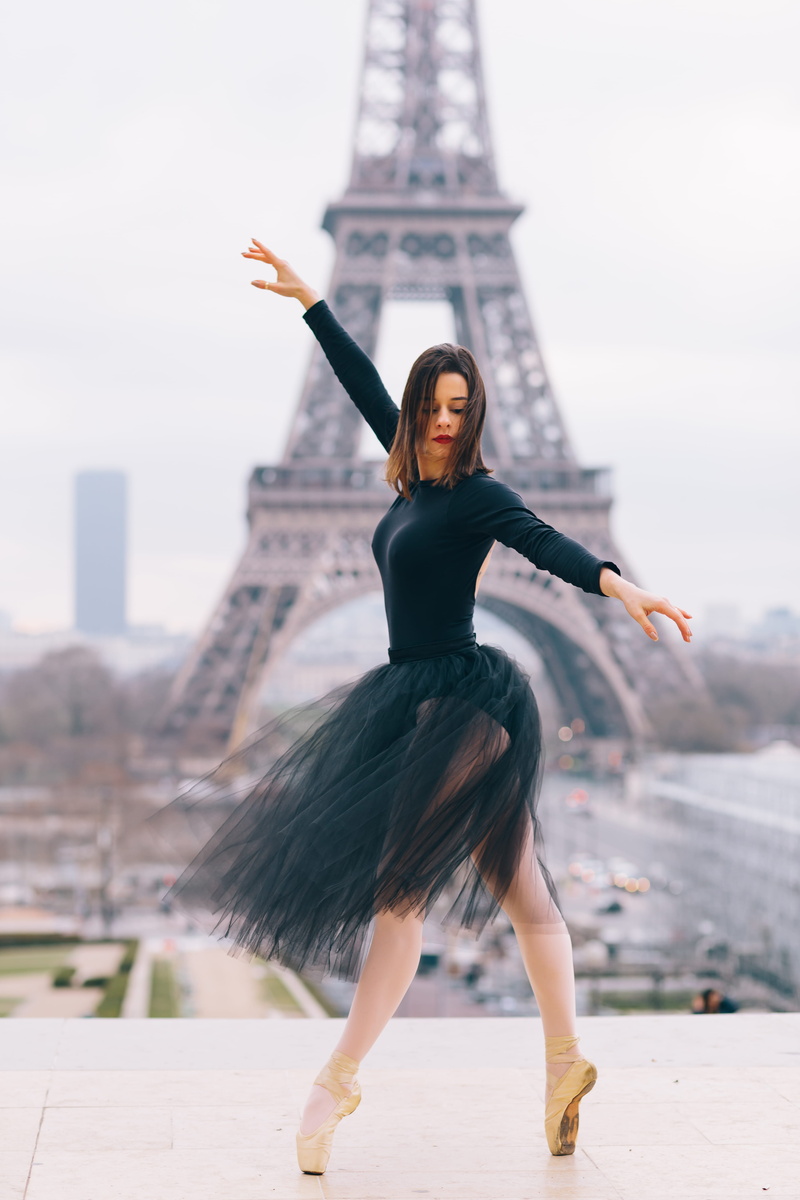 5K, outdoors, real people, front, leisure activity, beautiful woman, building exterior, paris, ballet dancer, tower, city, person, dance, eiffel, hairstyle