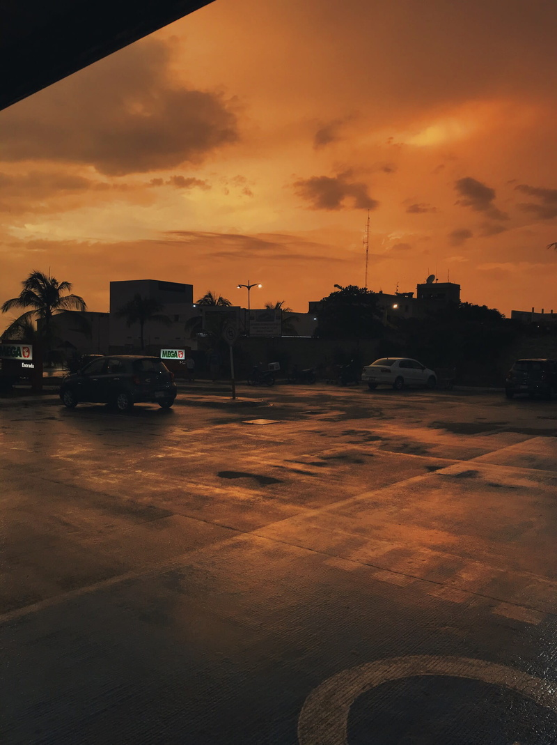 parking lot, no people, silhouette, split toning, building exterior, land vehicle, road, beauty in nature, orange color, nature, cars, car, motor vehicle