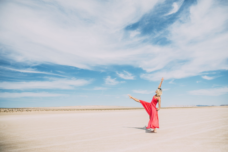 beauty in nature, leisure activity, women, caucasian, blue, desert, road, scenics - nature, dress, one person, beach, dancing, standing, land, cloud, flexible