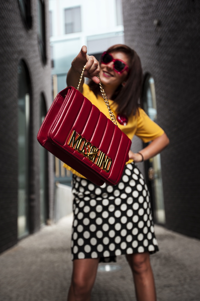 people, adult, pose, sunglasses, young, wear, fashion, outdoors, focus on foreground, t, man, handbag, polka dot, built structure, shirt, brunette, festival