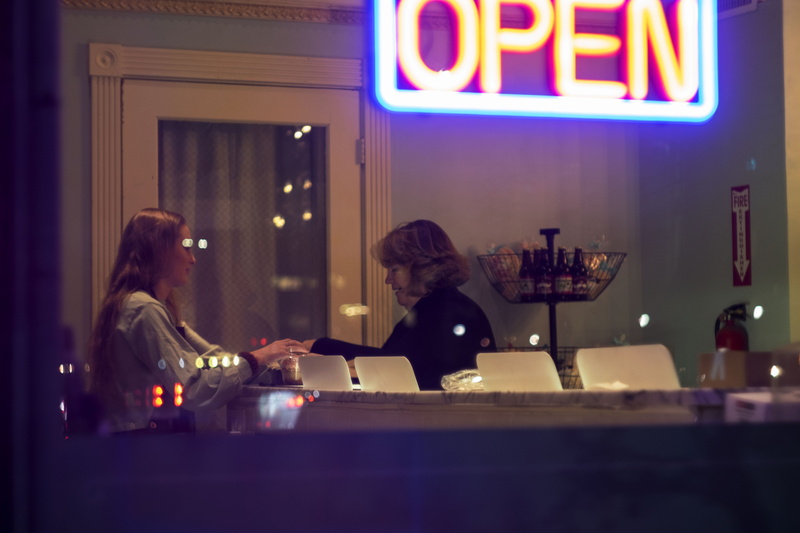 food and drink, indoors, adult, woman, table, business, sitting, restaurant, two people, cafe, communication, bakery, drink, people, illuminated, night