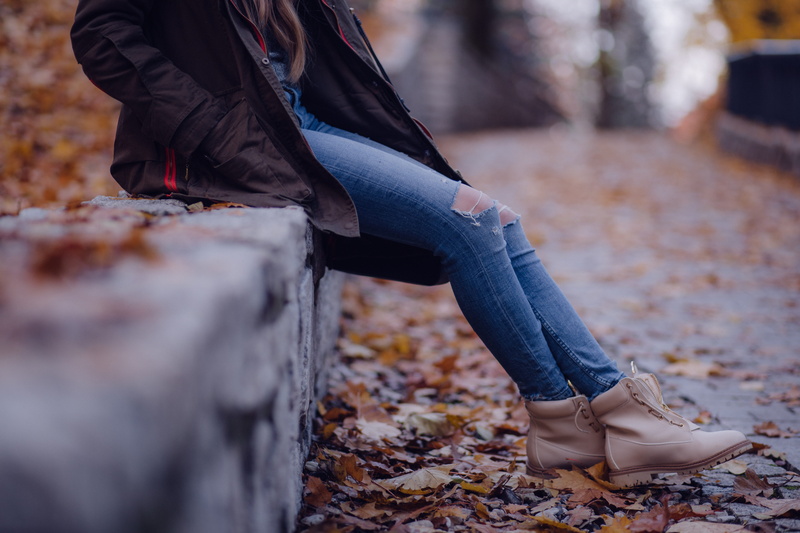 human foot, leather, fence, human leg, fall, person, real people, jeans, leaf, tattered pants, pants, distress, casual clothing, adult, sit, jacket, wood