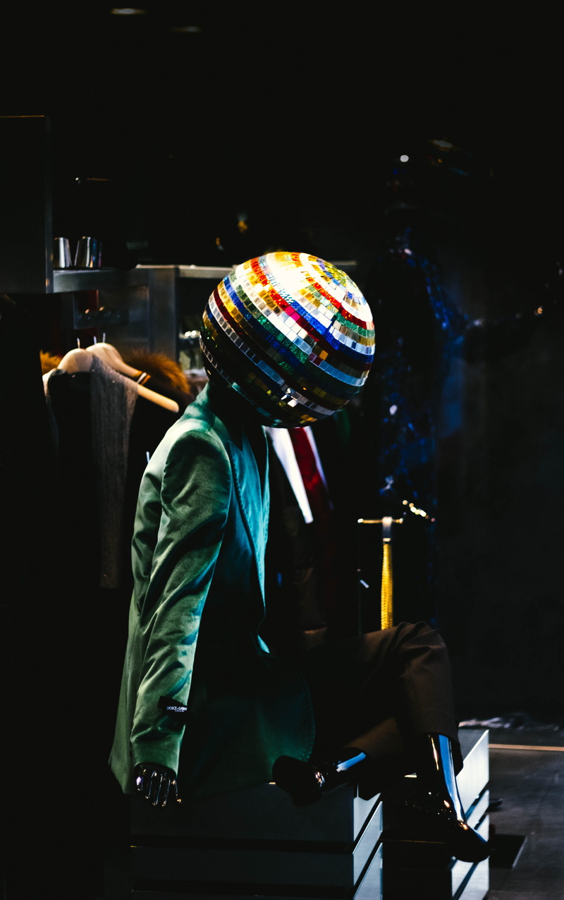 statue, disco ball, man, illuminated, person, side view, three quarter length, blue, men, blazer, occupation, head, holding, reflection, one person, mirror