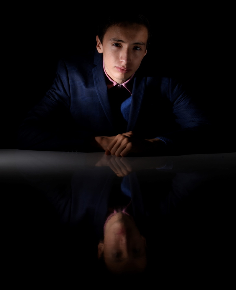 confidence, male, males, suit, sitting, young adult, serious, dark, wearing, blue, business person, looking at camera, man, teenager, model, studio shot