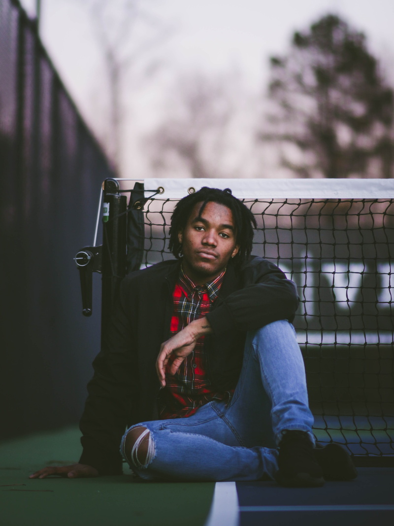 one person, beside, tennis court, wearing, jeans, males, denim, man, blazer, net, day, full length, nature, leaning, leisure activity, focus on foreground