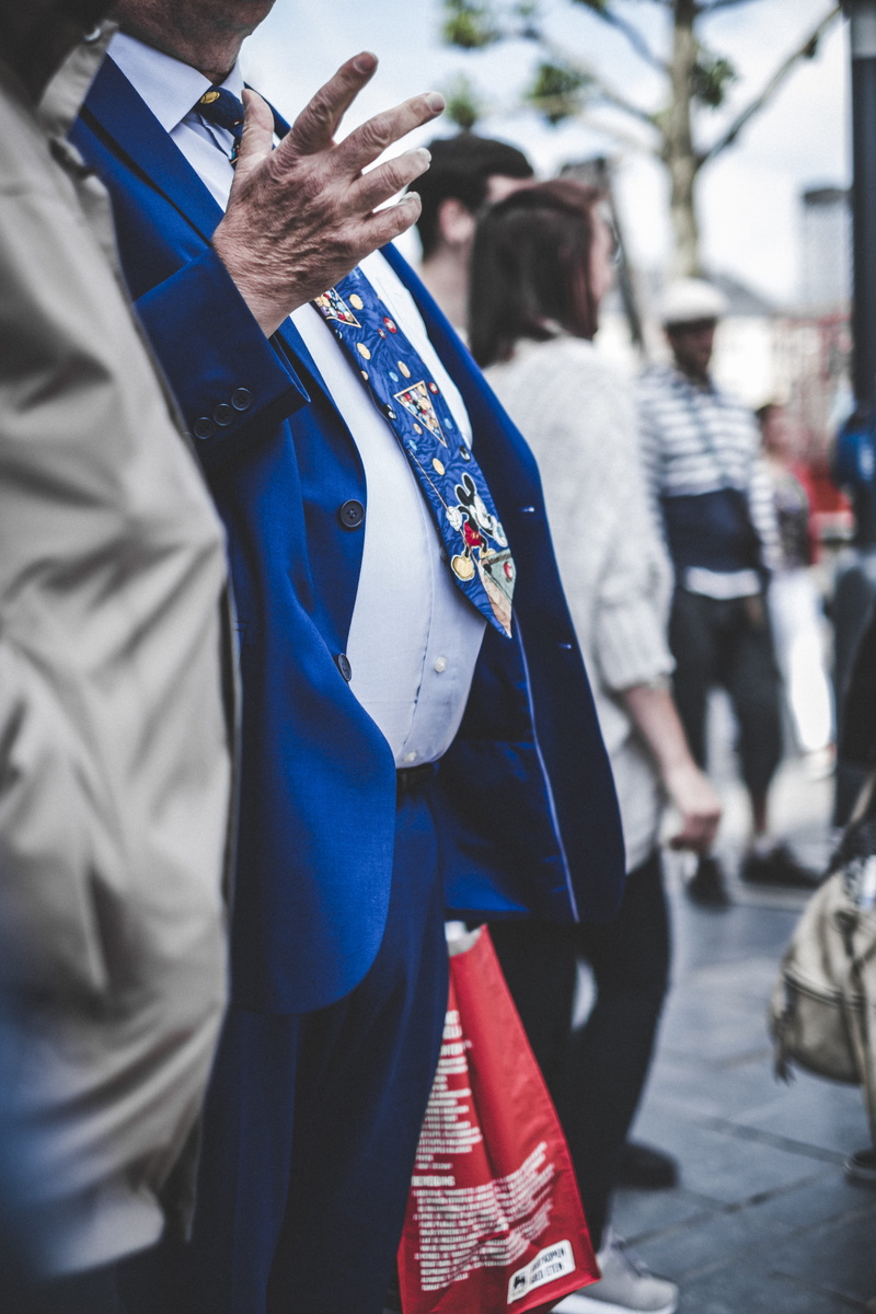 focus on foreground, liège, clothing, person, mouse, midsection, architecture, real people, walking, wrinkle, hand, obscured face, candid, man, human, accessories