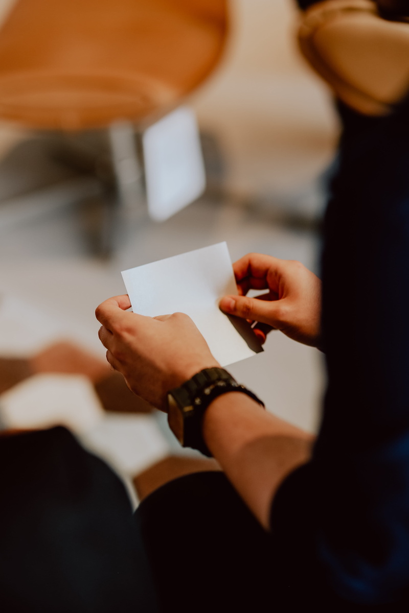 lifestyles, origami, holding, workshop, human body part, indoors, paper, sheet, hand, handmade, leisure activity, human hand, selective focus, 5K, focus on foreground