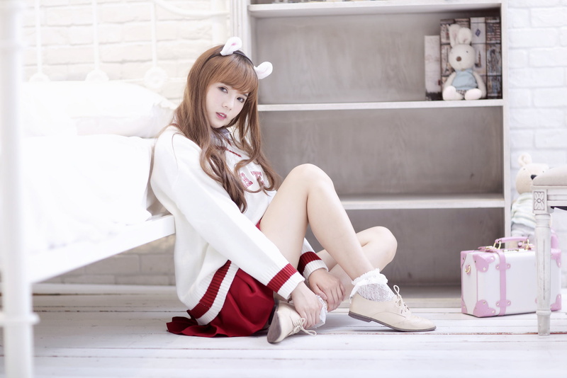 young adult, bed, fashion, one person, socks, lifestyles, long hair, Asian, headband, brunette, portrait, hair, shoe, shoes, sweater, sitting, skirt, beauty