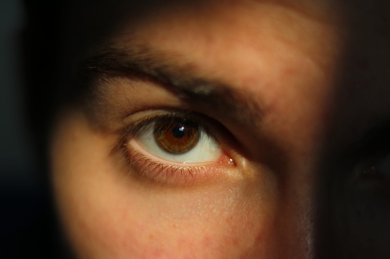 iris, face, eyesight, s, indoors, eyeball, human face, looking at camera, camera lens, iris - eye, black background, tape, selective focus, electronics