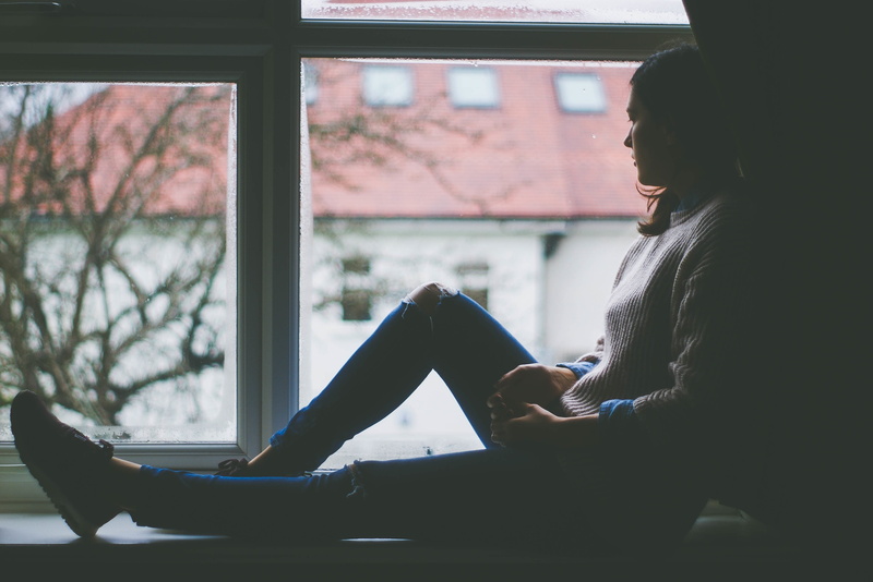 real people, watching, beautiful woman, wall, leaning, sitting, beside, side view, one person, lifestyles, window view, female, casual clothing, thinking woman