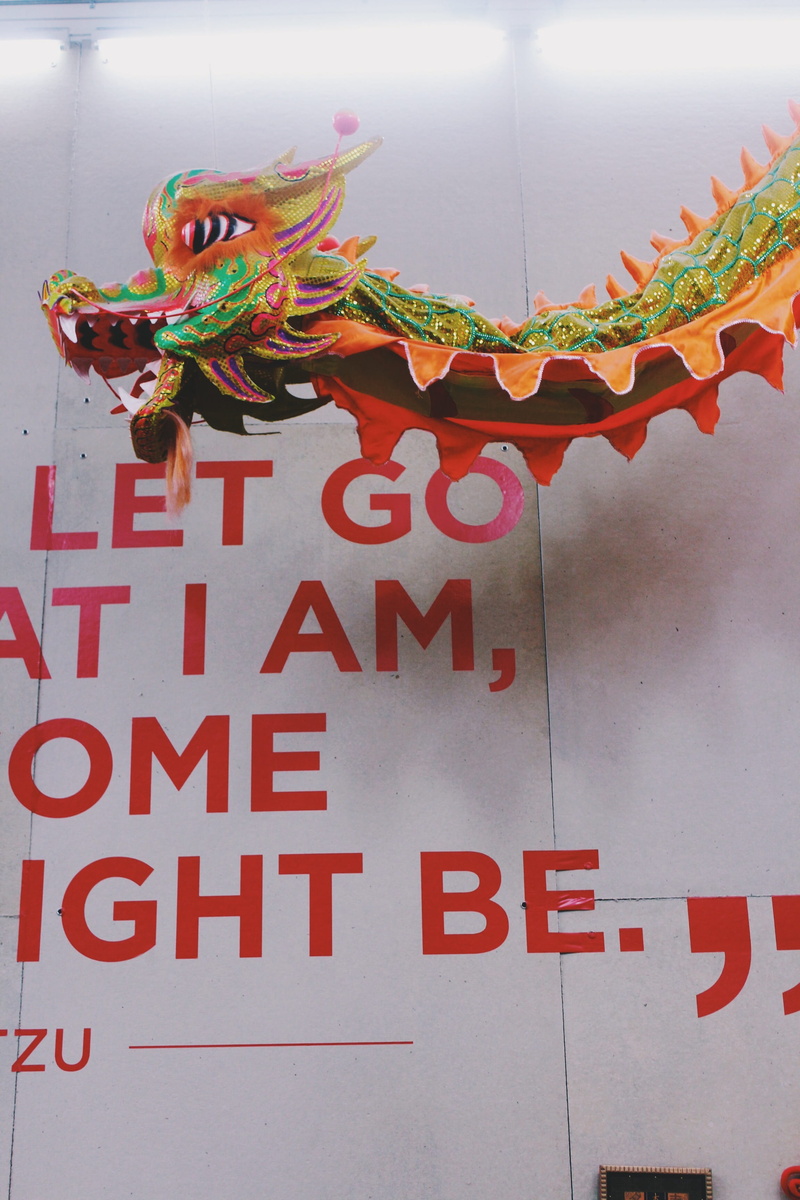 no people, dinosaur, built structure, representation, dragon, goblet, figurine, red, day, poster, advertisement, label, text, reptile, architecture, western script