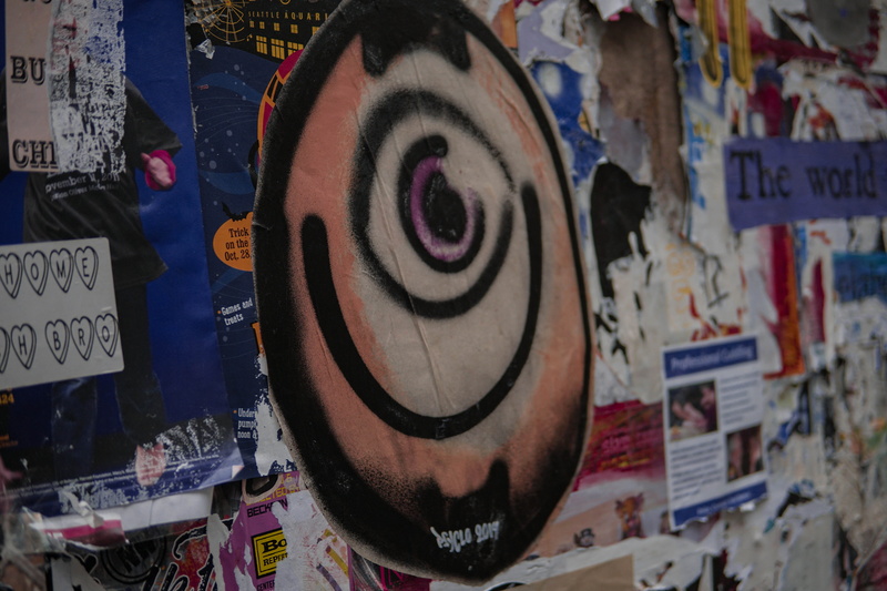 canvas, papers, hanging, human representation, arcade game machine, poster, advertisement, paint container, indoors, shopping, graffiti, multi colored