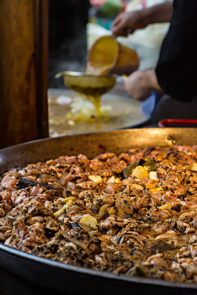 paella, kitchen utensil, incidental people, meat, indoors, unrecognizable person, 5K, real people, freshness, selective focus, united kingdom, human body part