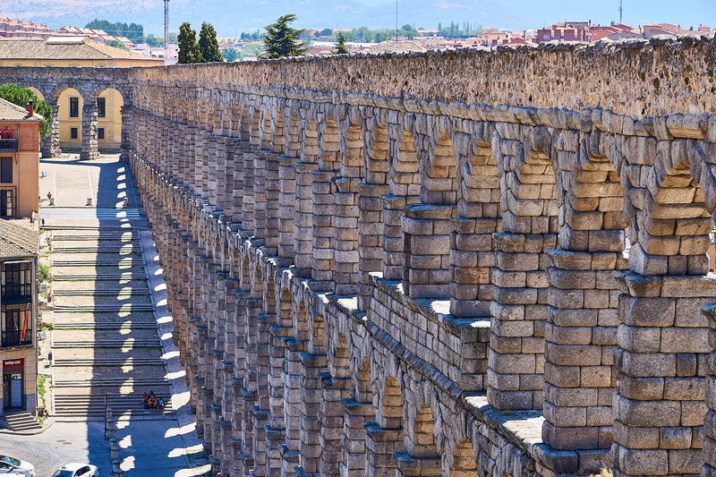 outdoors, building, history, in a row, aqueduct, structure, wall, roof, places of interest, house, segovia, stone wall, unesco world heritage site, sunlight