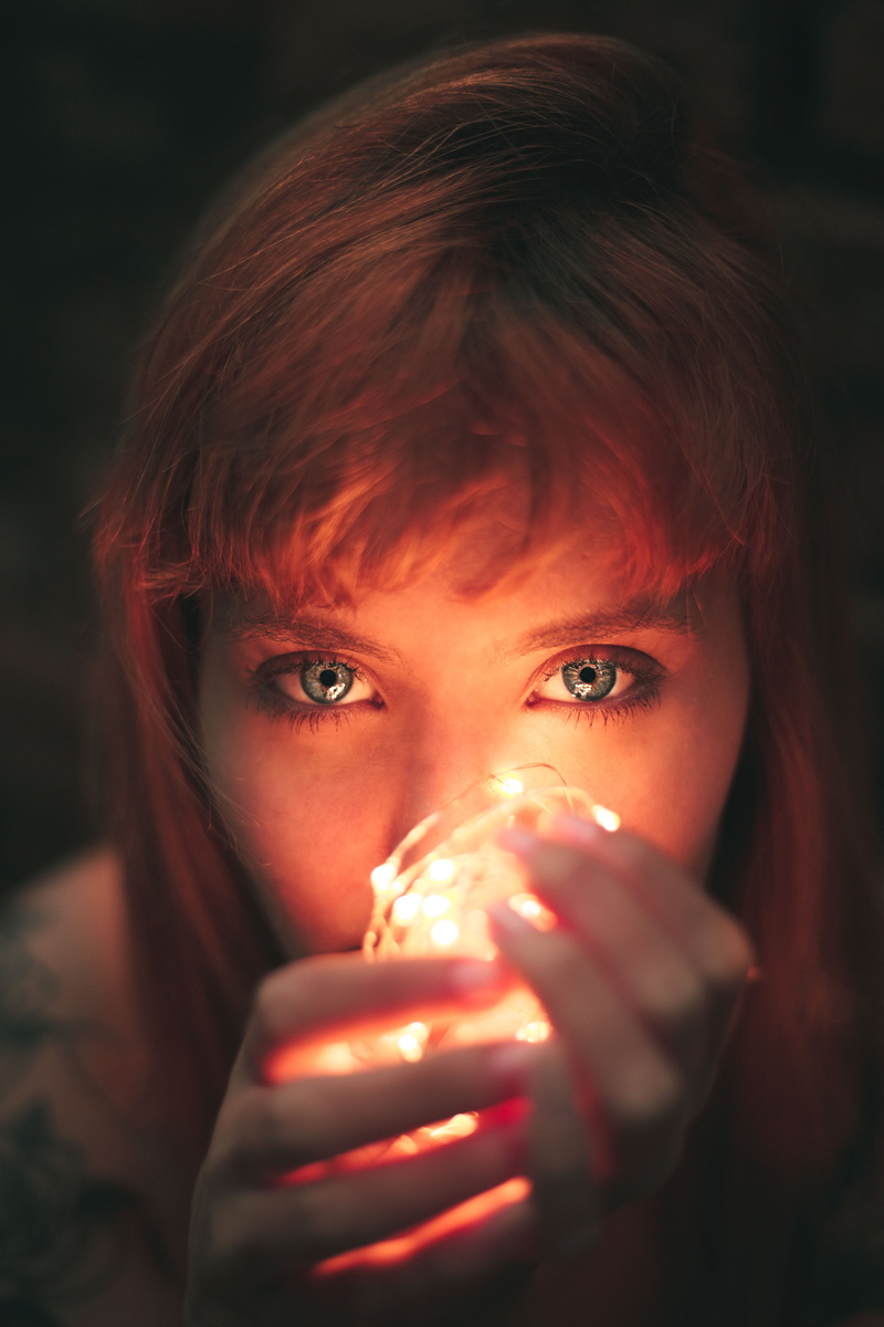 blur, close, body part, one person, blue eyes, looking at camera, close-up, redhead, lights, young adult, woman, food and drink, string, facial expression