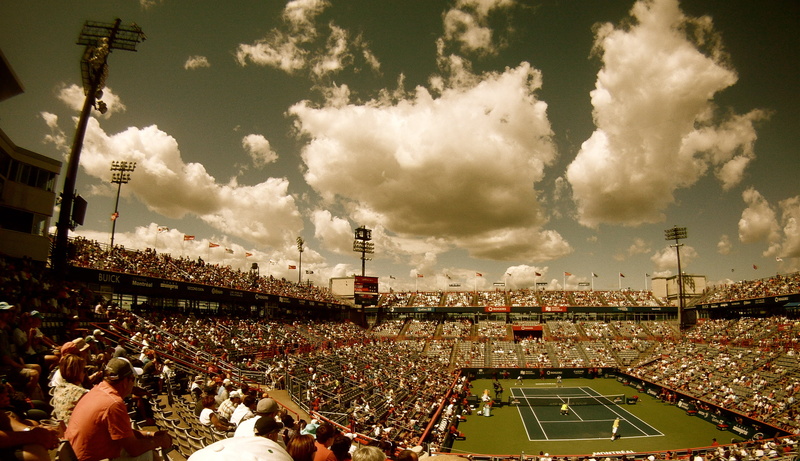 match - sport, leisure activity, fun, sitting, excitement, group of people, lawn, team sport, tennis, spectators, sky, net, clouds, flags, bench, fan - enthusiast