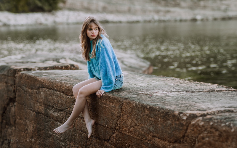 outdoors, lake, water, teenager, nature, blue clothing, jean shorts, blue sweater, fashion, dress, long hair, barefoot, 1080P, day, sitting, portrait