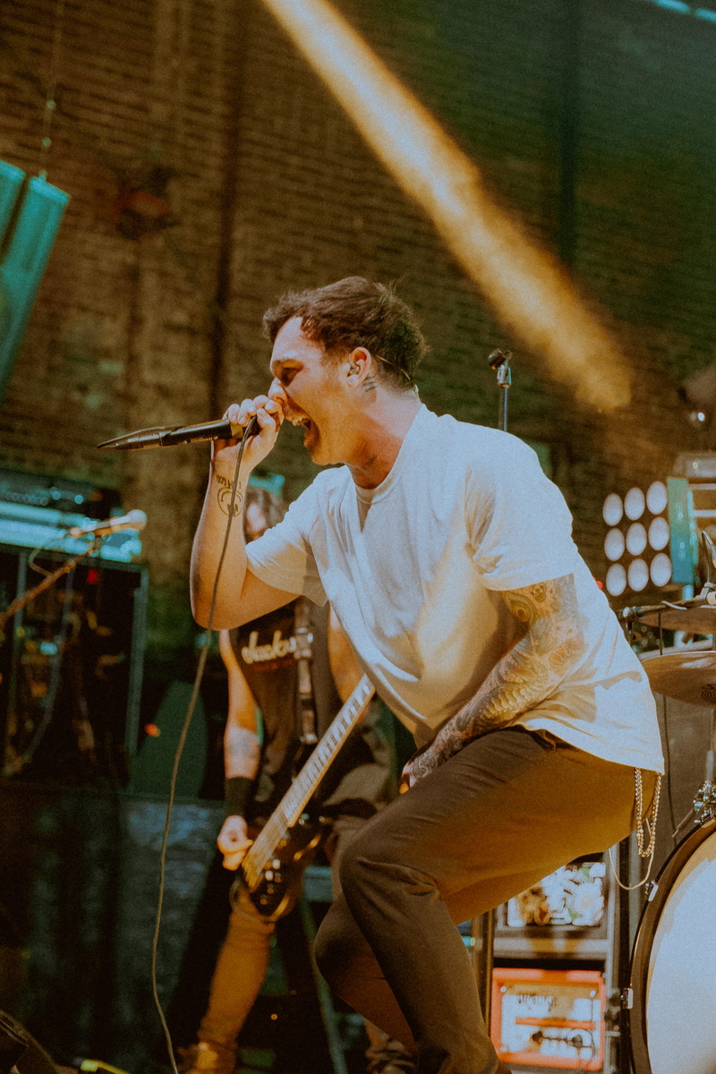 real people, holding, plucking an instrument, artist, crew, one person, skill, lighting, young men, person, white, music band, bass guitar, music, concert
