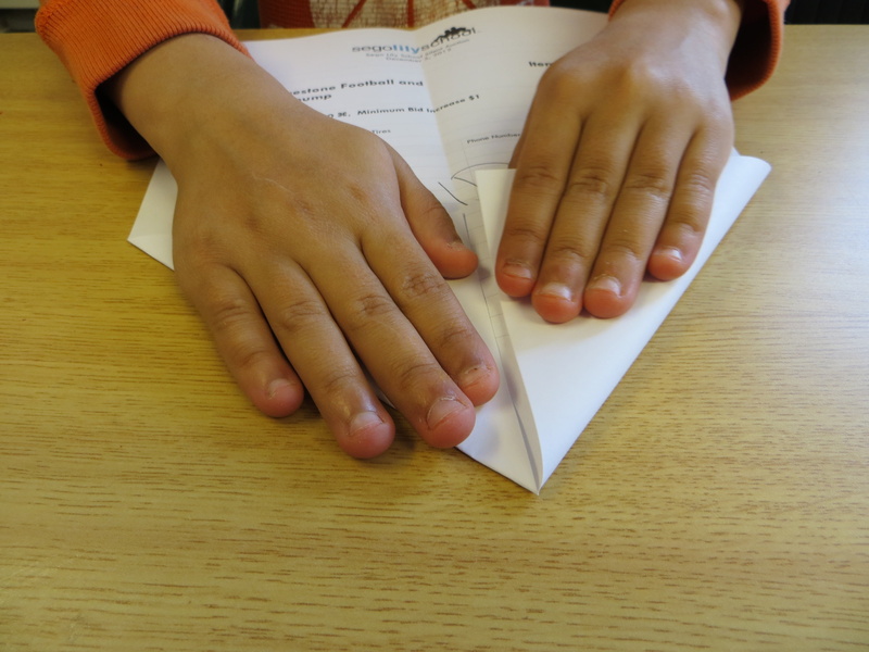 paper, aeroplane, one person, young, human hand, table, fun, hands, hand, high angle view, brown, human body part, lifestyles, real people, flying, crafty