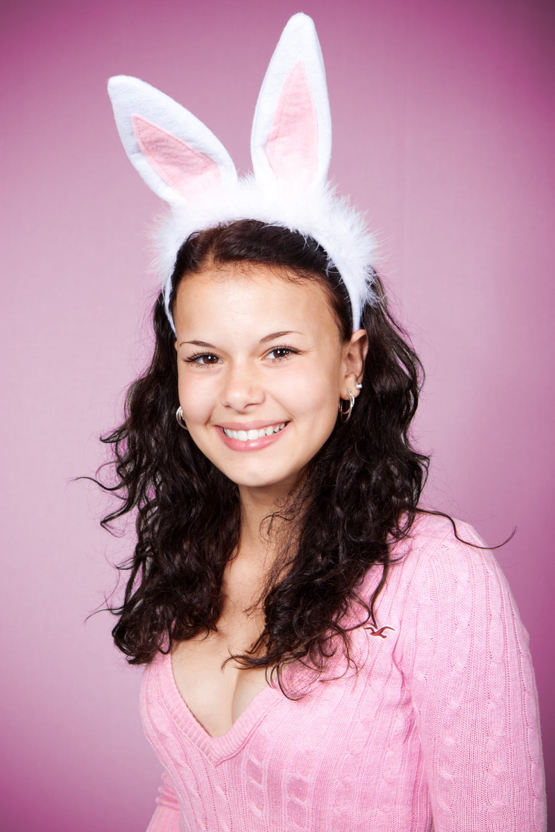 colored background, sweater, smiling, front view, cute, positive emotion, wearing, person, background, female, indoors, 4K, celebration, pink background