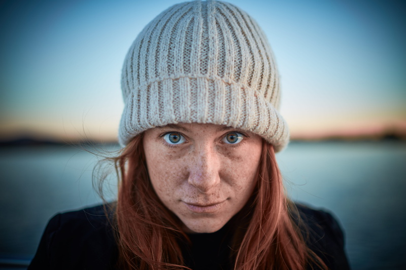 wearing, freckles, close-up, hair, knit, sunset, hat, beautiful woman, selfie, gray, 8K, beanie, focus on foreground, green, clothing, cap, taking, eye