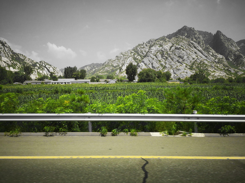 transportation, green color, tranquility, tarmac, nature, grass, vehicle, grey, day, hill, green, no people, mountain, countryside, train, beauty in nature