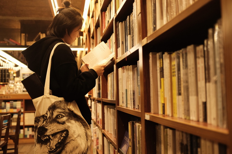 library, holding, girl, china, 2K, real people, bookshelf, one person, leisure activity, three quarter length, education, bookshop, learning, guangzhou shi