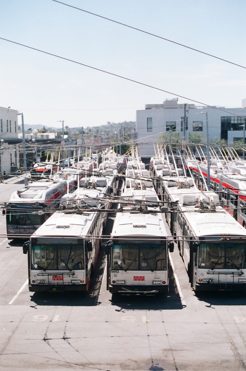 car, street, building exterior, cable, sky, motor vehicle, built structure, streetcar, road, automobile, traffic jam, building, no people, parking, way