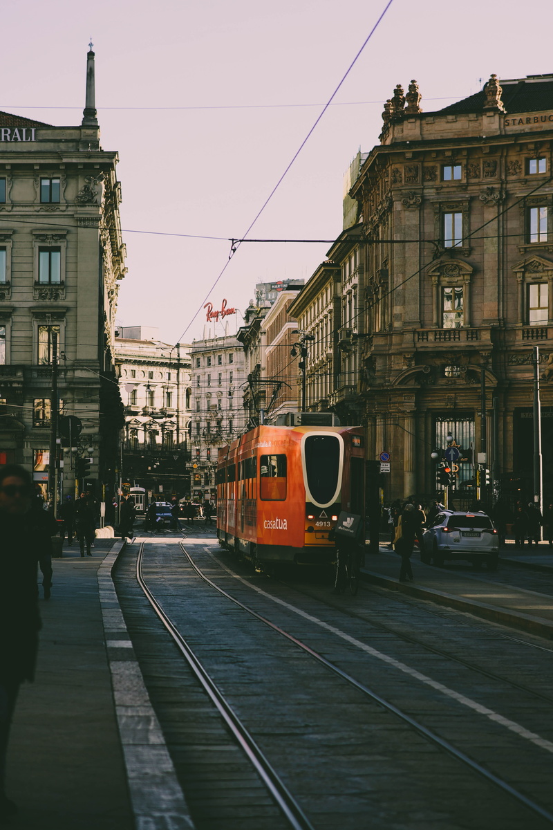 incidental people, architecture, beside, cable, building exterior, built structure, town, urban, street in milan, vehicle, cable car, public transportation