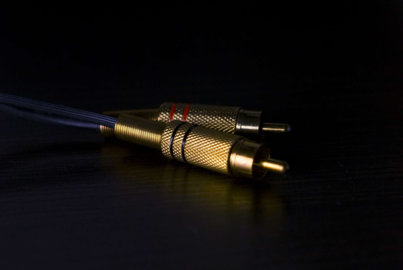 reflection, 2K, table, metal, high angle view, plug, weapon, aggression, gold colored, connector, audio, indoors, close-up, colored background, no people