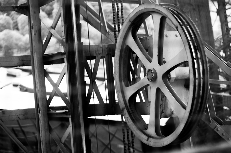 elevator, full frame, pulley, geometric shape, outdoors, mode of transportation, wheel, metal, transportation, iron, wagon wheel, industrial, day, close-up