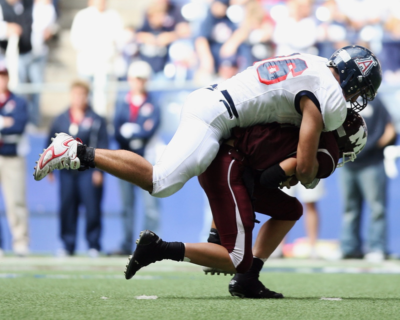 player, defense, outdoors, tackle, artificial surface, field, incidental people, number, stadium, lifestyles, action, play, running, american football