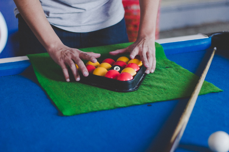 furniture, one person, man, playing, leisure games, cue sport, human, pool table, balls, nightlife, human hand, person, table, adult, billiard room, sport