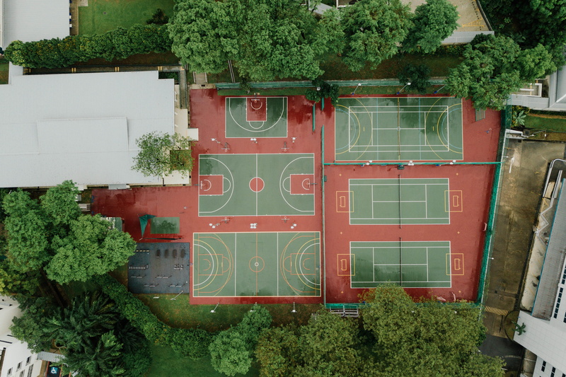 building exterior, green color, field, transportation, tree, sports, photography, court, outdoors, drone view, text, photo, no people, day, wall - building feature