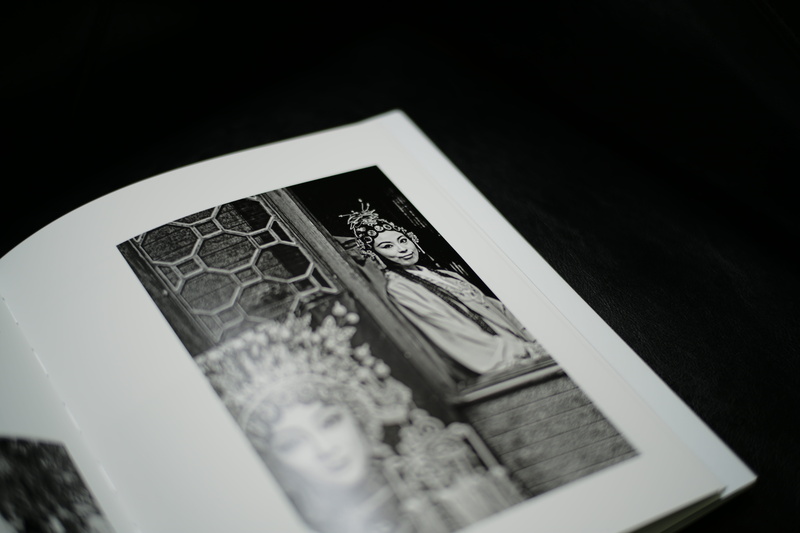 brochure, selective focus, page, photobook, paper currency, close-up, woman, dining room, indoors, male likeness, person, black background, monochrome