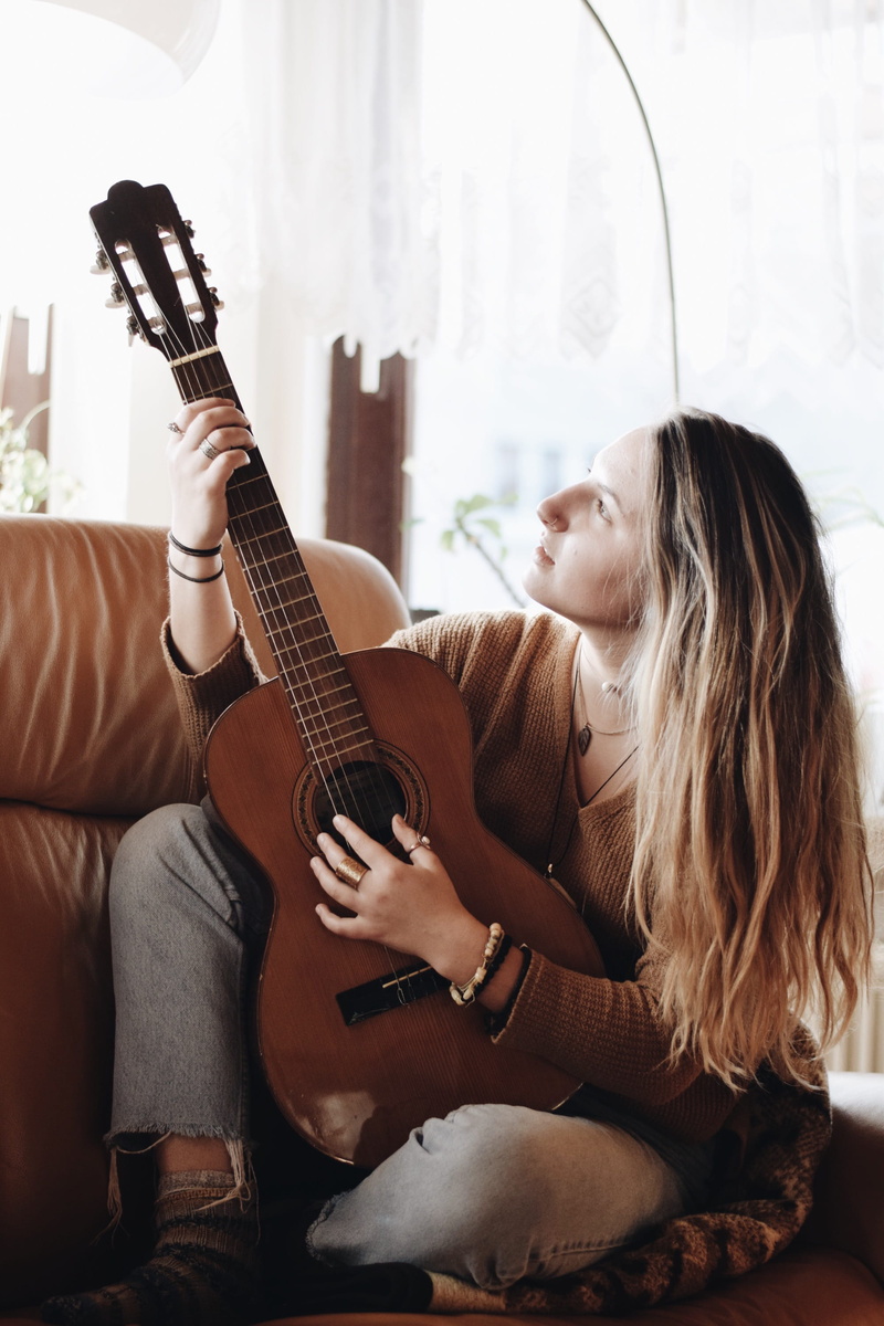 inside, arts culture and entertainment, musician, person, classical guitar, girl, bass guitar, musical equipment, woman, hippie, young adult, hair, domestic room