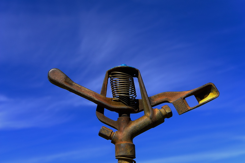 sprinkler, no people, blow up, weathered, agriculture, water, day, outdoors, blue, clear sky, close-up, nature, single object, antique, environment, old