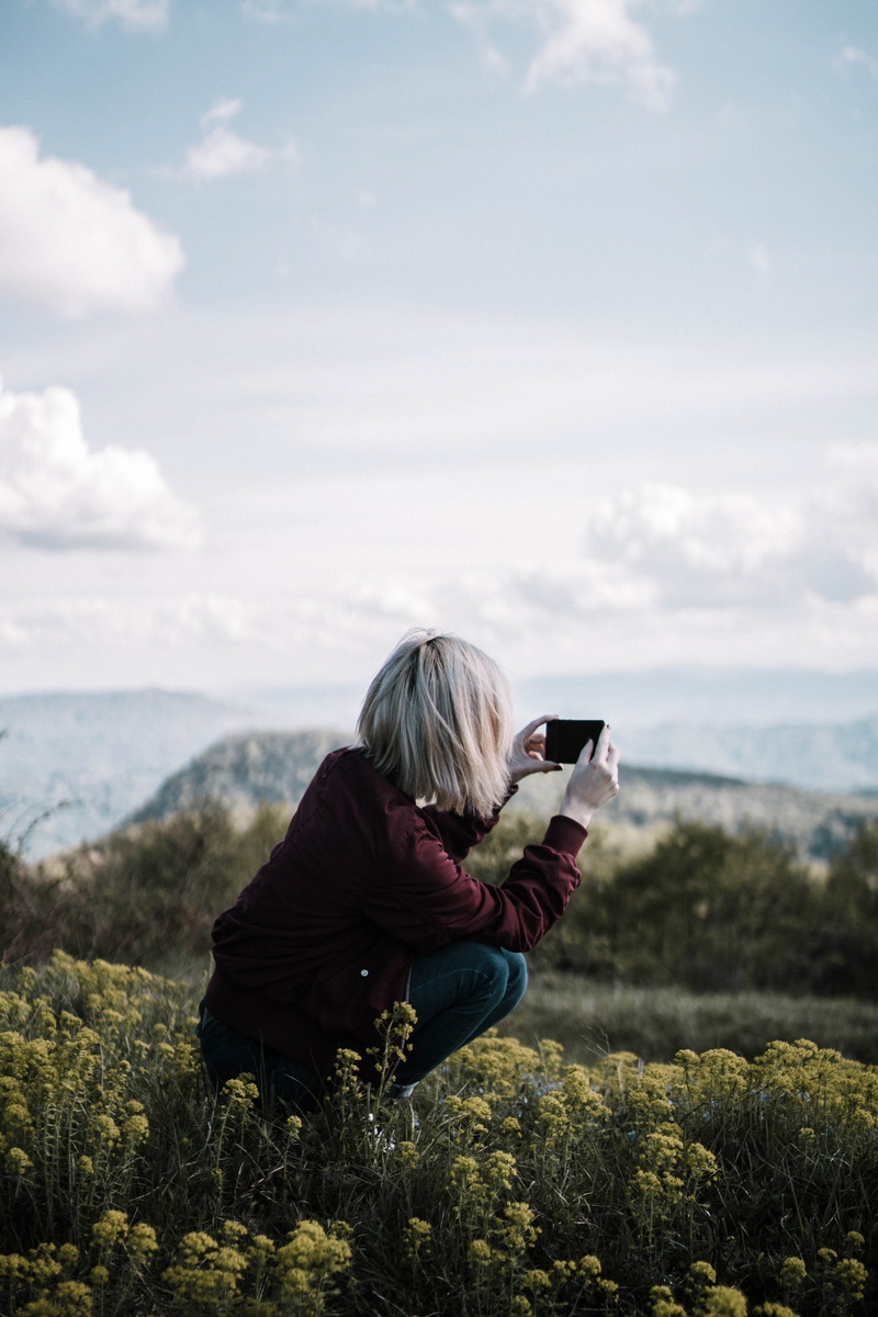 looking, modern, taking photo, beauty in nature, trees, photography themes, blurred background, person, cellphone, cloud - sky, wear, one person, photographer