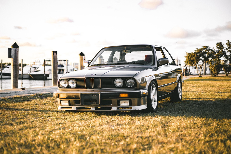 outdoors, e30, sky, travel, bmw, field, car, motor vehicle, parked, black, nature, old car, auto, coche, plant, sunlight, land vehicle, lawn, stationary