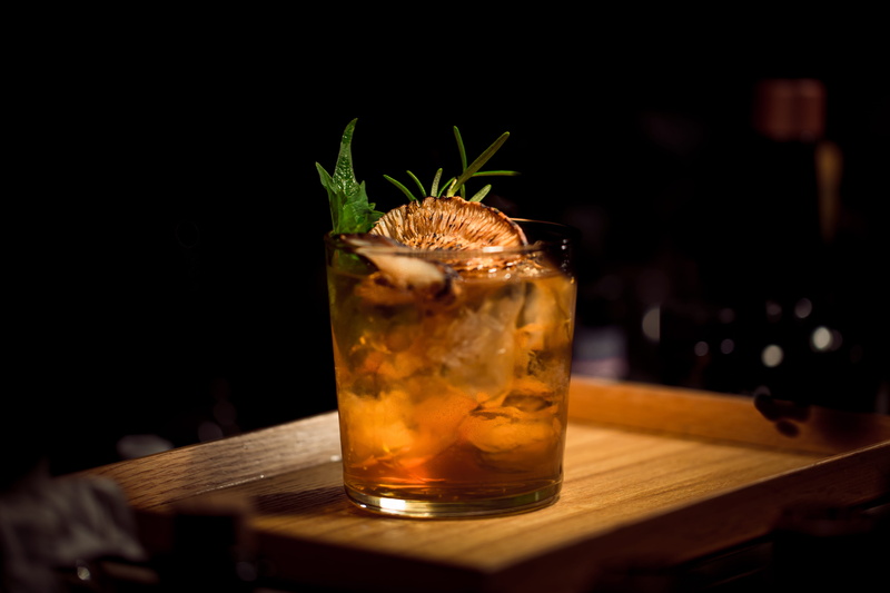 drinking glass, glass, drink, rum, table, alcohol, tray, food, shot, mojito, household equipment, food and drink, garnish, dark, refreshment, hard liquor