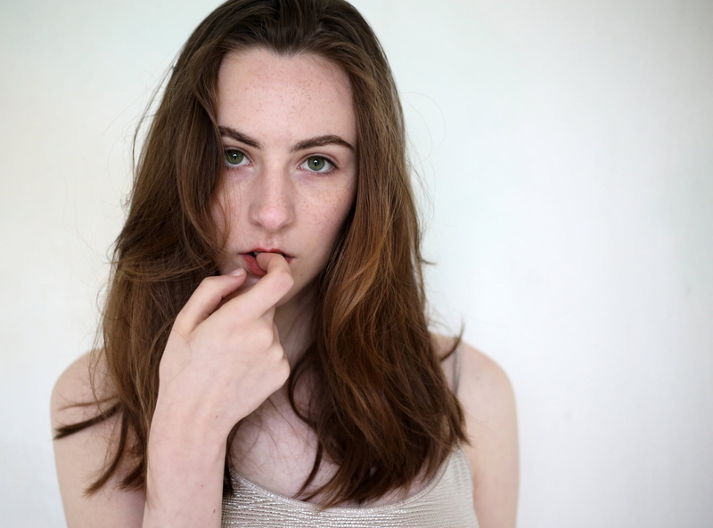 one person, uncertainty, adult, mouth open, beautiful woman, long hair, young adult, contemplation, hands covering mouth, portrait, emotion, indoors, looking at camera