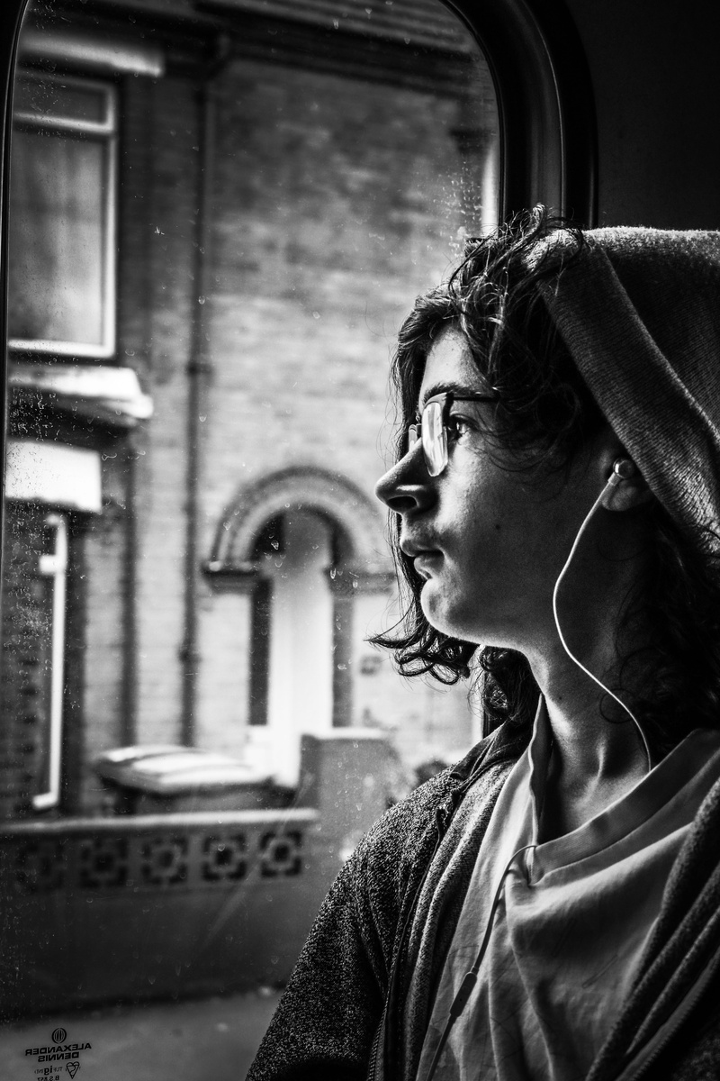 young adult, photo, headshot, glasss, day, inside, capture, urban, lifestyles, window, earphones, one person, 5K, side view, looking, architecture, looking away
