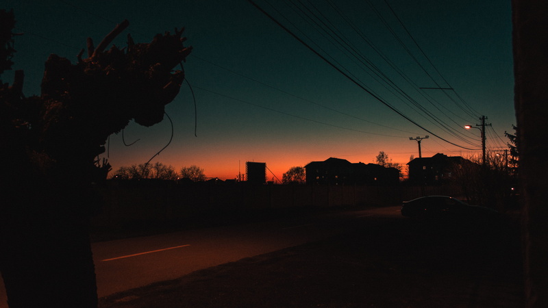 technology, trees, motor vehicle, nature, houses, built structure, telephone line, dark, street, sky, mode of transportation, cable, no people, light, outdoors
