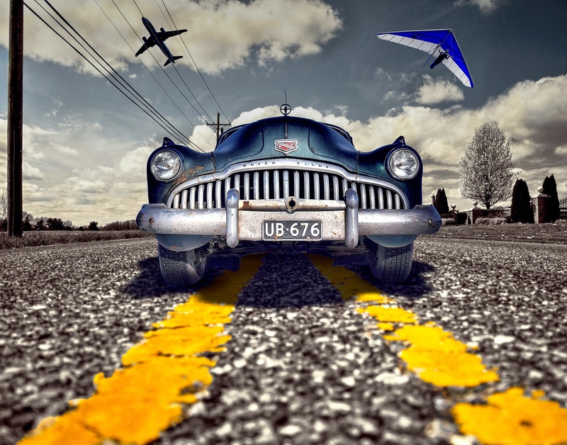 flight, street, outdoors, overhead cables, marking, transmission line, asphalt, travel, city, motor vehicle, no people, classic cars, overhead lines, plane