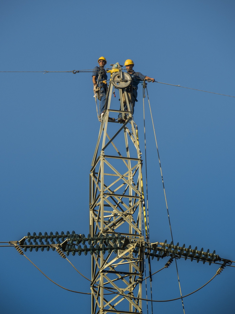 danger, outdoors, complexity, workers, fixing, clear sky, working, connection, electricians, low angle view, electrical, nature, power supply, cable, sky