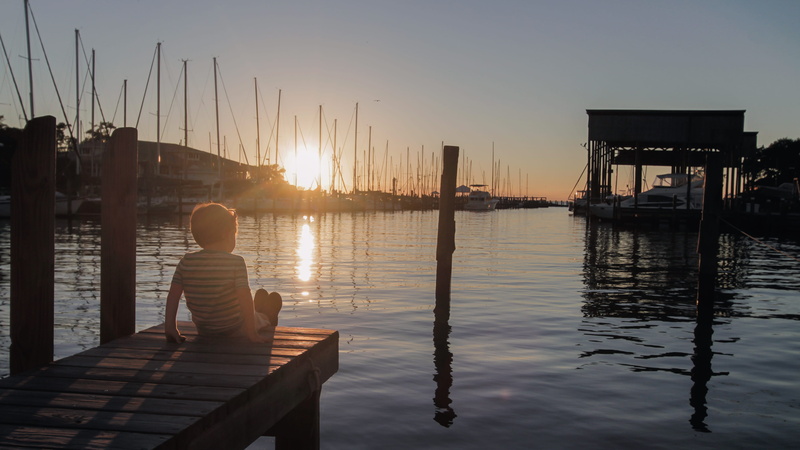 pier, adoration, scenics - nature, procession, sunlight, sitting, lifestyles, one person, sun, rear view, eucharist, religious, reflection, real people