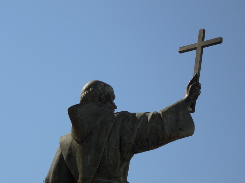 sky, low angle view, catholic, male likeness, art and craft, statue, symbol, cross, day, sculpture, craft, no people, clear sky, 5K, belief, human representation