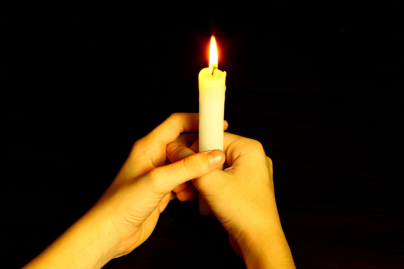 communion, indoors, fire, hands, human finger, black background, illuminated, candle, holding, body part, human limb, human hand, one person, prayer, human body part