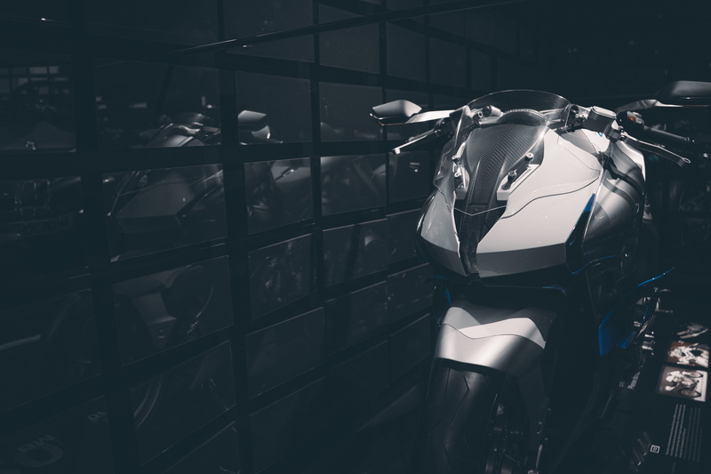 street, museum, focus on foreground, motor, motorcycle, industry, shallow, sunlight, black, outdoors, chrome, animal, mode of transportation, BMW, germany
